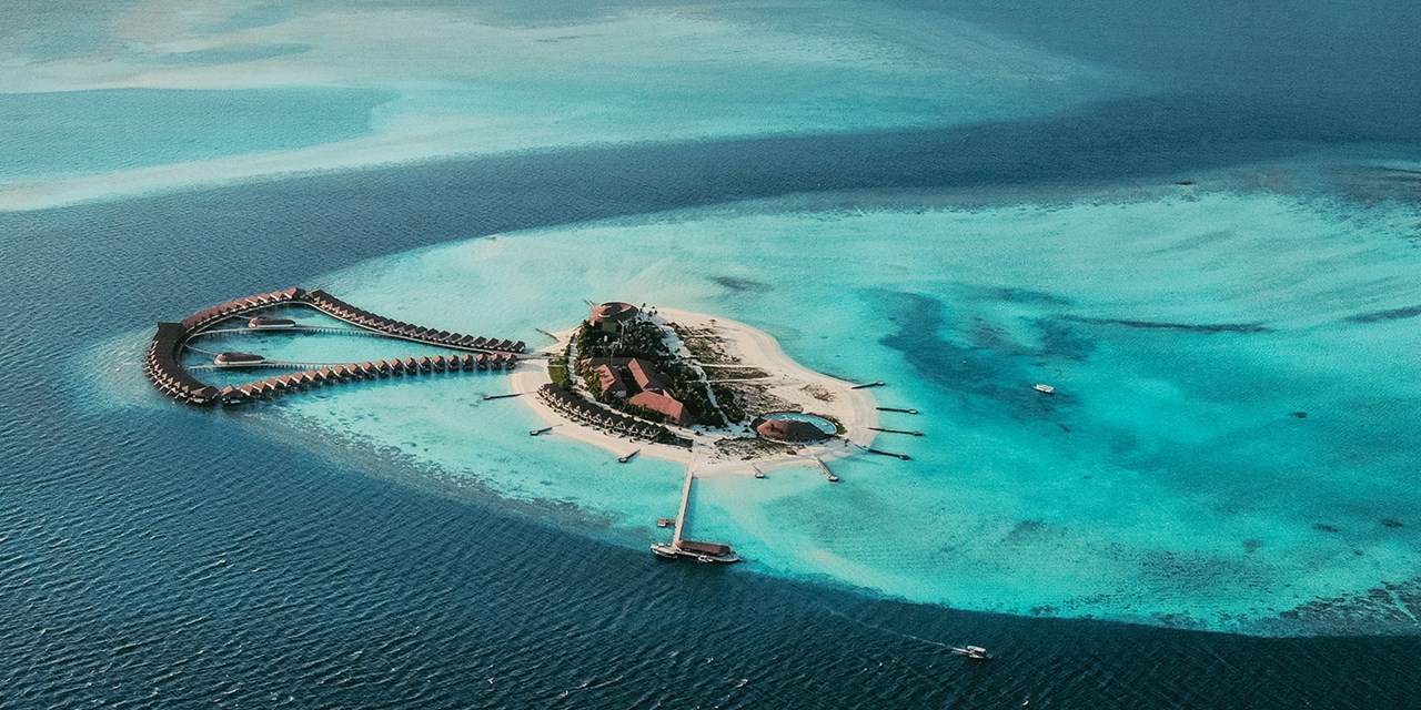 An aerial view of Cinnamon Velifushi showcases its pristine beaches and turquoise lagoon