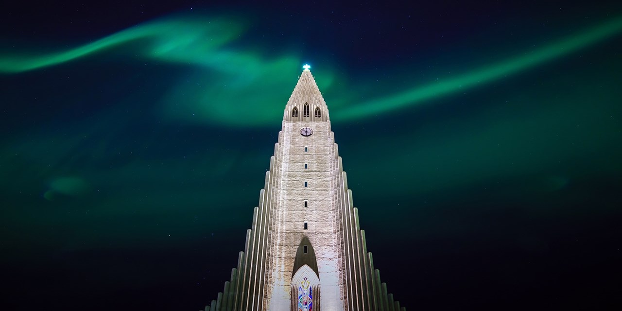 Northern lights ripple above Hallgrimskirkja church in Reykjavik