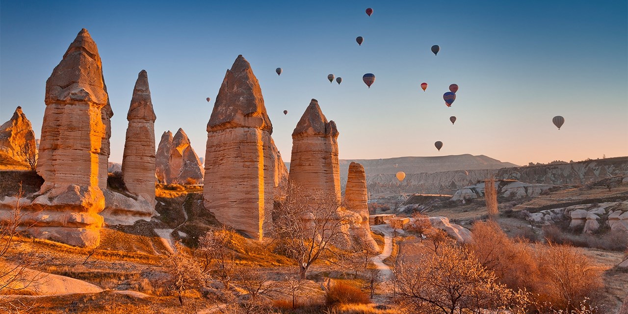 The fairy chimneys and hot air balloons at sunrise in Cappadocia
