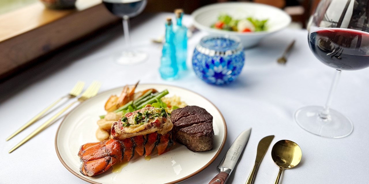 Enjoy surf 'n' turf at your window-side table during the dinner cruise