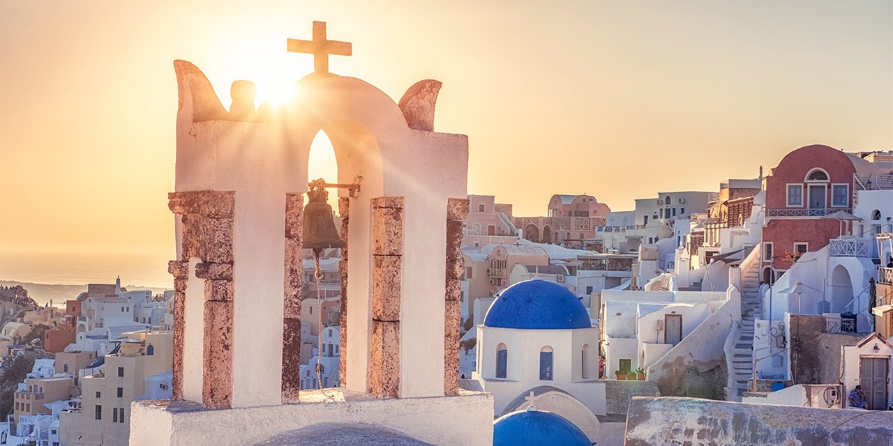 A traditional whitewashed bell tower in Oia on a sunny day