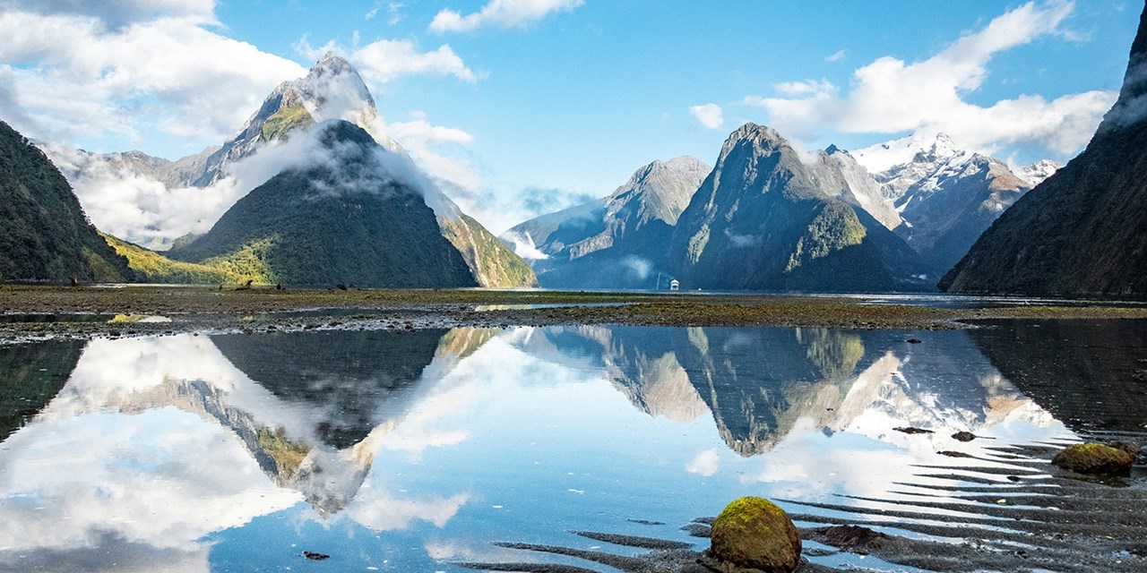 Admire the snowy peaks and that frame the clear waters of Milford Sound in Fiordland National Park in New Zealand