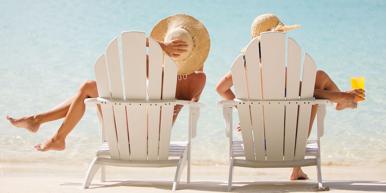 Beachgoers relax in chairs along Antigua's shoreline