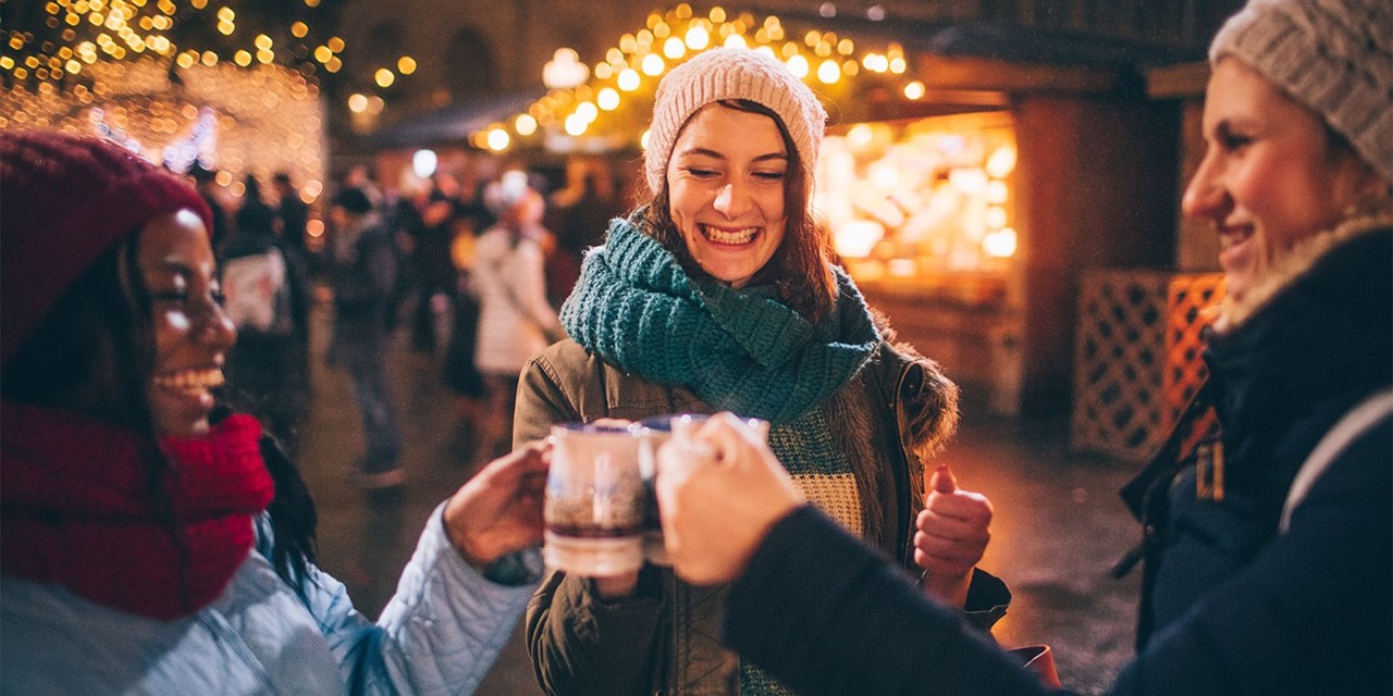 Brindando con un vino caliente durante una visita a los mercados de Navidad