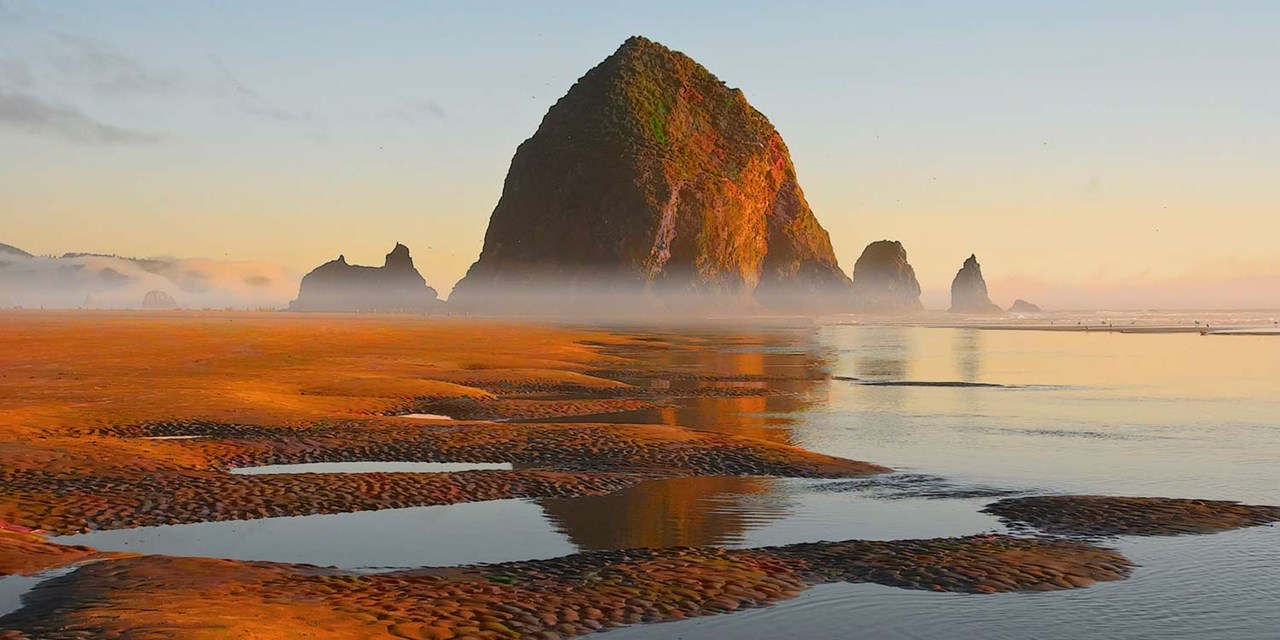 Snap pics in front of the towering Haystack Rock along the coast